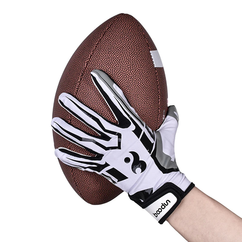 Gants de sport en silicone noir et blanc anti-dérapants posés sur un ballon de football marron.
