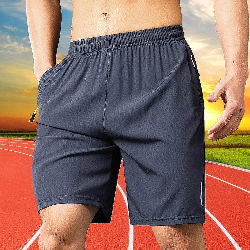 A man wearing dark blue men's quick dry jogging shorts standing on a running track.