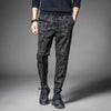 Men's camouflage elastic waist drawstring pants shown on a model standing against a gray background.