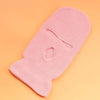 A pink tactical knit balaclava beanie hat lying on an orange background.