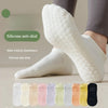 Chaussettes de yoga en silicone anti-dérapantes et anti-chute blanches sur un pied.