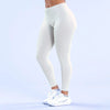 A person wearing white high-waisted seamless yoga leggings and white athletic shoes.