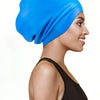 A woman wearing a bright blue silicone swim cap for long hair and braids.