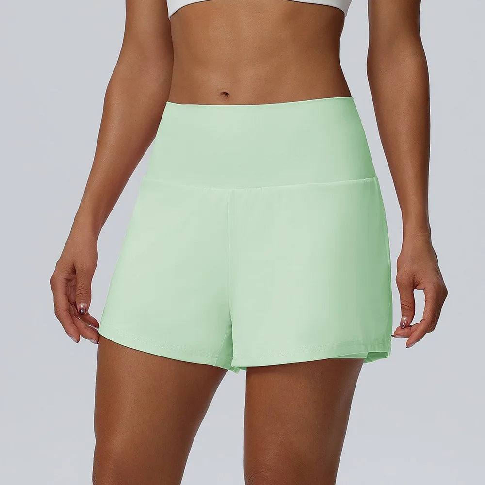 Eine Frau modelliert hellgrüne, schnelltrocknende sportliche Shorts.