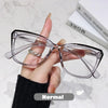 Eine Hand hält eine klare photochromische multifokale Brille vor weißem Hintergrund.