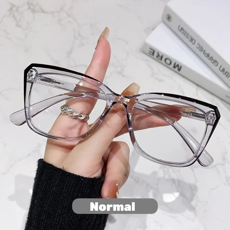Eine Hand hält eine klare photochromische multifokale Brille vor weißem Hintergrund.