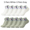 A collection of ten pairs of ankle socks, five white and five gray.