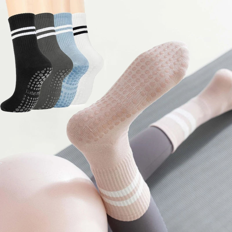 Primer plano de cuatro pares de calcetines de yoga y pilates antideslizantes para mujer en varios colores apilados.