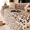 A plush leopard print sofa cover blanket draped over a sofa with decorative pillows and accessories.