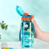 A hand is holding a blue dinosaur silicone straw water bottle with an orange lid and a clear liquid inside.