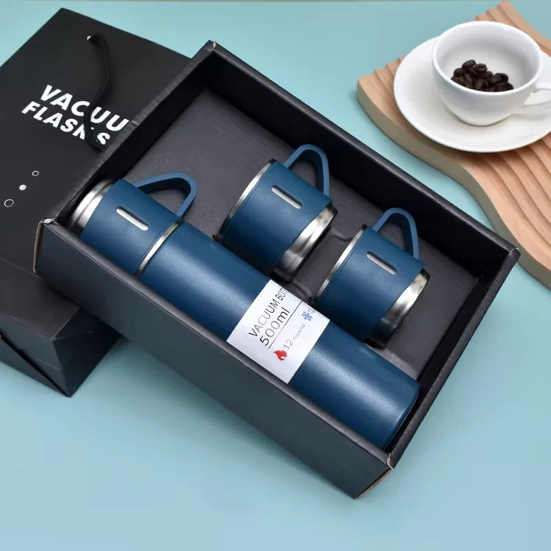 A dark blue vacuum flask is displayed inside a black box with multiple flasks, set on a light blue surface.
