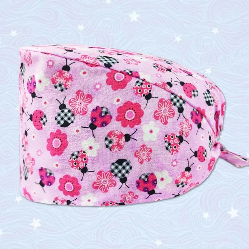 Pink printed cotton surgical cap featuring small floral and insect patterns