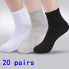 Ein Set aus drei Knöchelsocken in Weiß, Hellgrau und Schwarz wird auf einer Oberfläche präsentiert.
