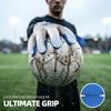 A hand wearing goalkeeper gloves grips a soccer ball for ultimate grip.