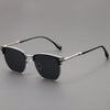A pair of black sunglasses with a metal frame and UV400 protection resting on a gray surface.