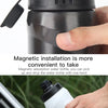 A hand is holding a white water bottle with a black magnetic cap, demonstrating the quick-release installation.