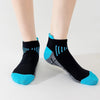 A pair of black knit sports socks with bright blue accents and stripes, shown on a person's foot.