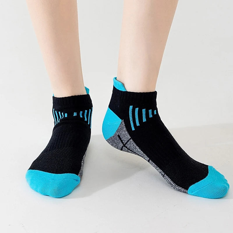 A pair of black knit sports socks with bright blue accents and stripes, shown on a person's foot.