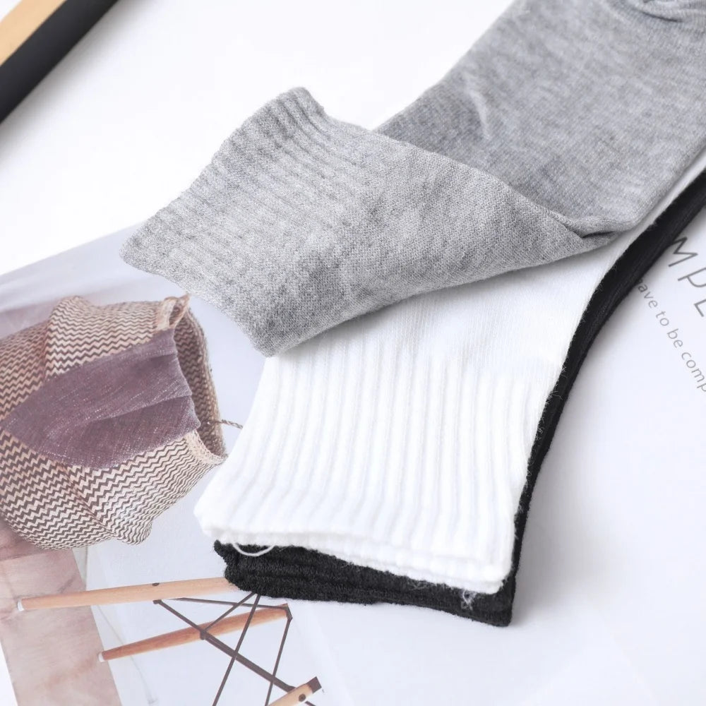 A close-up of gray and white men's mid-calf cotton socks displayed on a white background.