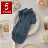 Five pairs of blue knitted mesh lace tube socks displayed on a white plate.