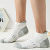 A pair of light gray and white athletic mesh ankle socks worn on a person's foot.