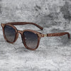 Brown wood grain polarized sunglasses with wooden arms resting on a gray textured surface.