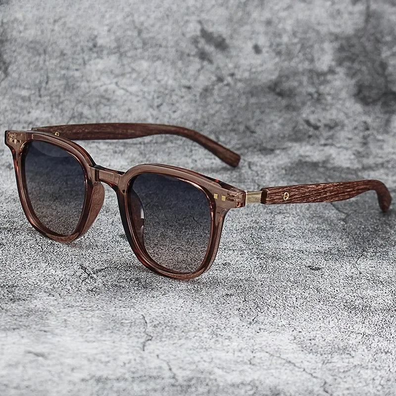 Brown wood grain polarized sunglasses with wooden arms resting on a gray textured surface.