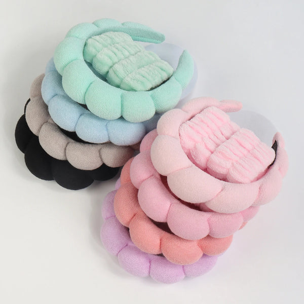 A set of pastel green, blue, and pink microfiber skincare headbands and wristbands.