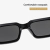 A close-up view of black square sunglasses with nosepads, designed to reduce pressure during wear.