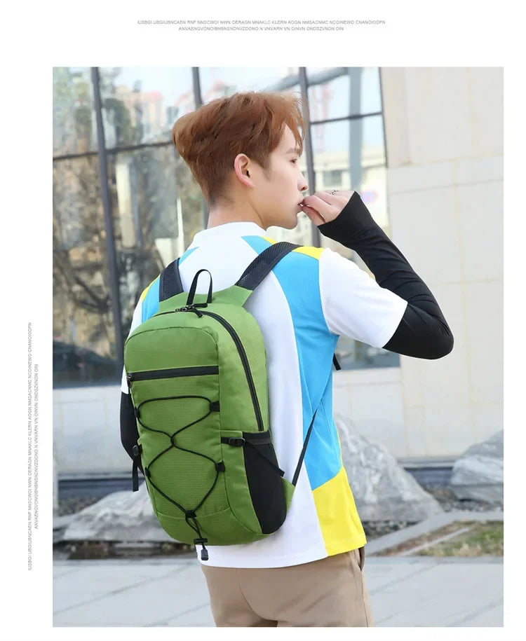 A young man wearing a white and blue shirt and khaki pants is carrying a large green backpack outdoors.