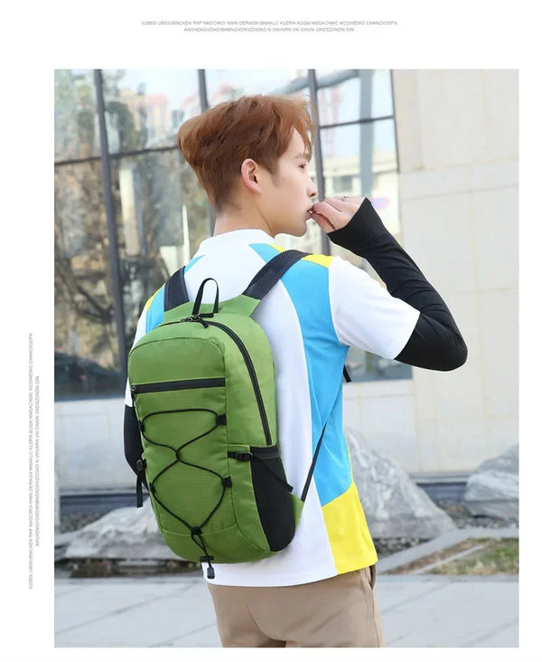 A young man wearing a white and blue shirt and khaki pants is carrying a large green backpack outdoors.