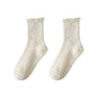 A pair of white cotton ruffle ankle socks shown flat.