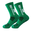 A pair of green anti-slip performance sports socks with white text and diamond patterns.