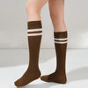 A pair of brown striped cotton knee high socks worn on a person's legs.