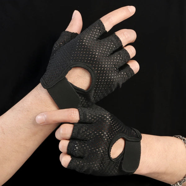 A hand wearing black breathable quick-drying cycling and fitness gloves against a dark background.