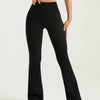 A woman wearing black high-waisted bootcut yoga pants and a black crop top.