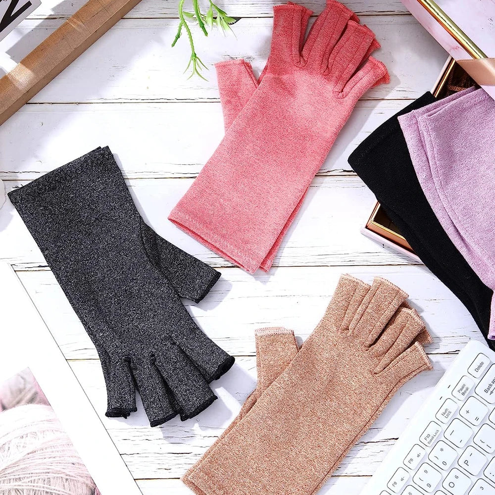 A collection of various colored compression hand gloves, including pink, black, and tan shades, displayed on a white wooden s