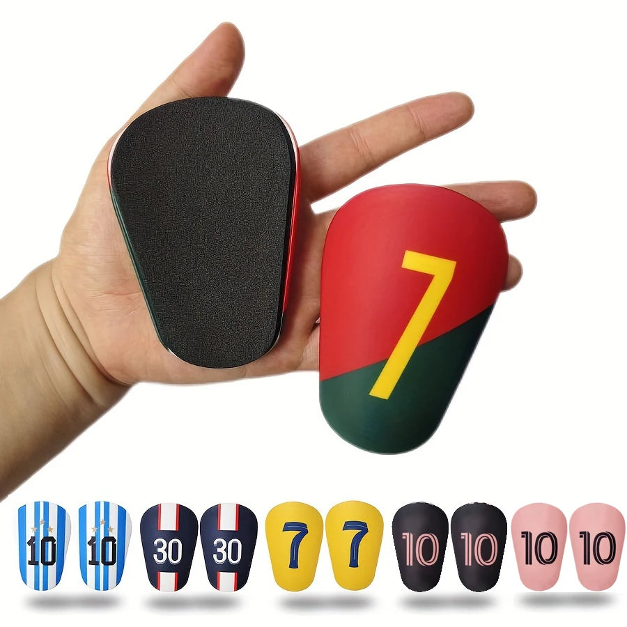 A collection of mini football shin guards in various colors and sizes, including blue, black, red, yellow, and pink.