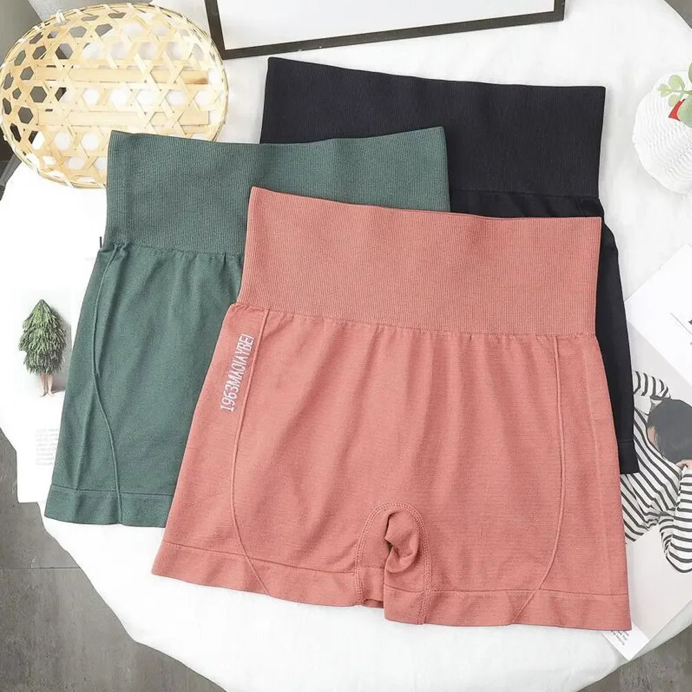 Una pila de mallas deportivas sin costuras para mujeres en tonos verde oliva, rosa empolvado y negro.