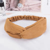 A brown fabric headband made of chiffon is shown lying on a white surface.