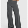 A model is wearing dark gray high waisted wide leg yoga pants in a studio setting.