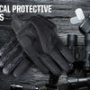 A pair of black tactical protective gloves lying on a dark surface next to various outdoor and sport equipment.