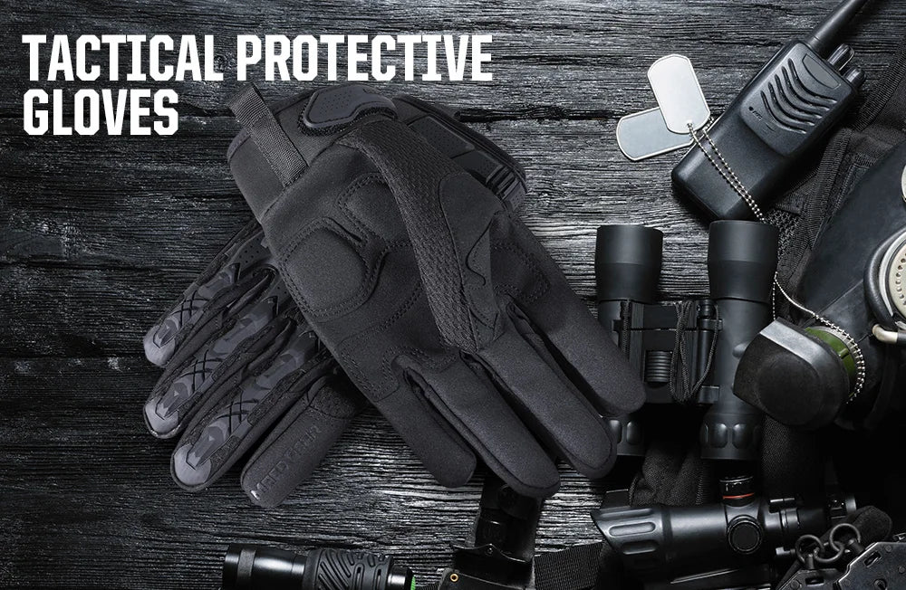 A pair of black tactical protective gloves lying on a dark surface next to various outdoor and sport equipment.