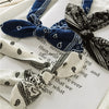 Gros plan de bandeaux de tête à motif paisley bohème bleu marine et blanc sur du papier.