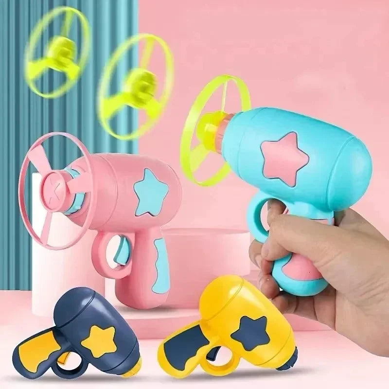 Une main tient un jouet disque interactif rose et bleu pour chats, avec plusieurs disques jaunes visibles.