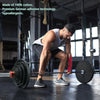 A muscular man performs a squat exercise using a barbell and weights in a gym setting.