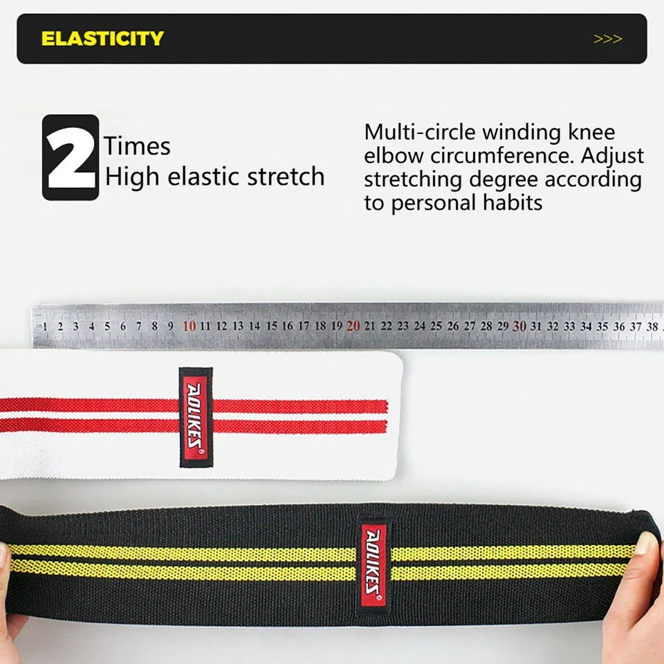 Black elastic knee wraps with red and yellow stripes shown next to a ruler.