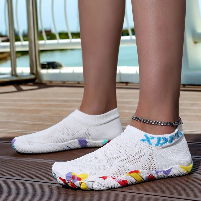 White waterproof quick-dry outdoor hiking shoes worn on a wooden deck.