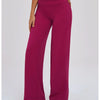 A woman wearing magenta high-waist wide-leg yoga leggings and silver sneakers.