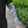 Close-up of a person wearing an ice silk tattoo sleeve featuring colorful, swirling dragon designs on their arm.